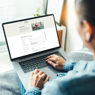 Woman on laptop enrolling in direct primary care